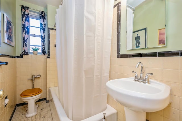 full bathroom with sink, tile patterned flooring, toilet, tile walls, and shower / tub combo