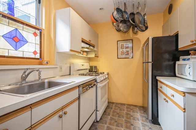 kitchen with white appliances, white cabinetry, and sink