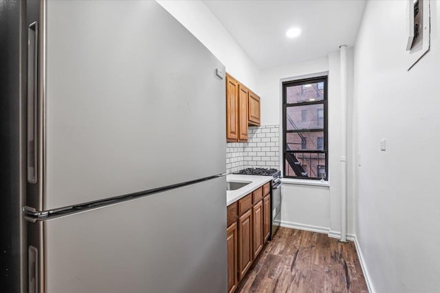 kitchen with stainless steel appliances, tasteful backsplash, and dark hardwood / wood-style floors