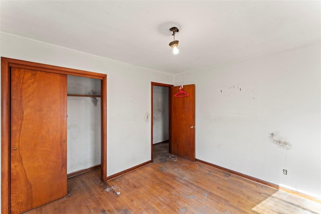 unfurnished bedroom with a closet and hardwood / wood-style flooring