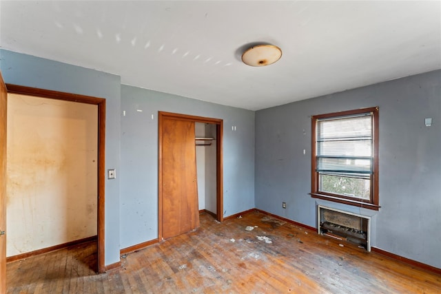 unfurnished bedroom featuring wood-type flooring and a closet