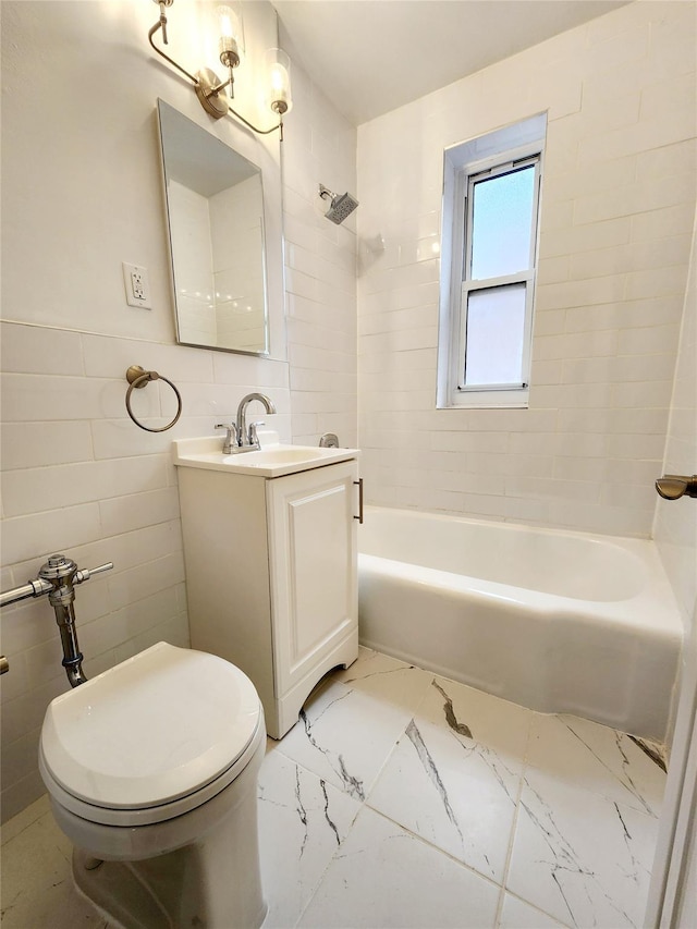 full bathroom with tile walls, vanity, tiled shower / bath combo, and toilet