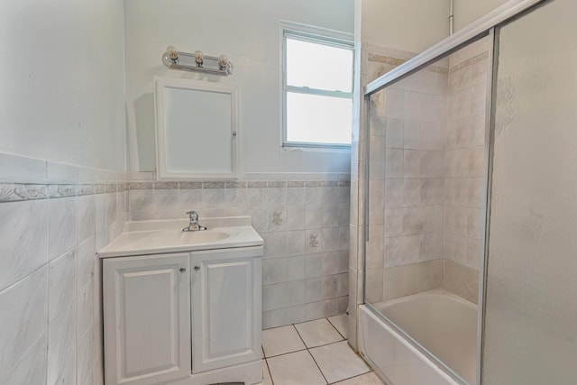 bathroom with tile patterned floors, vanity, enclosed tub / shower combo, and tile walls