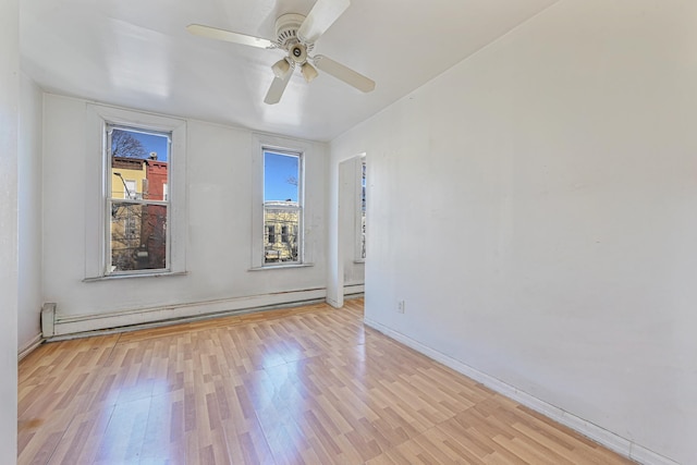 spare room with a baseboard radiator, light hardwood / wood-style flooring, and ceiling fan