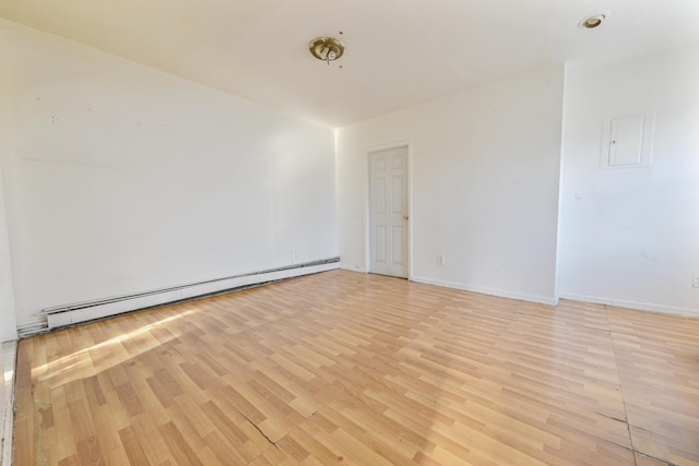 spare room with baseboard heating and light wood-type flooring