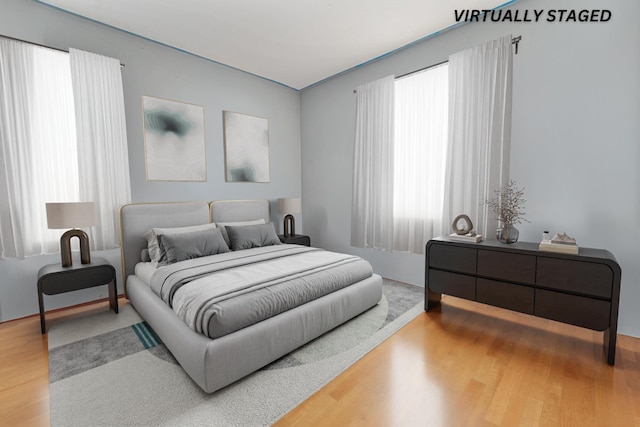 bedroom featuring hardwood / wood-style floors and multiple windows