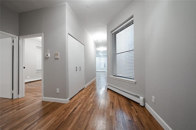 hall with dark hardwood / wood-style flooring and baseboard heating