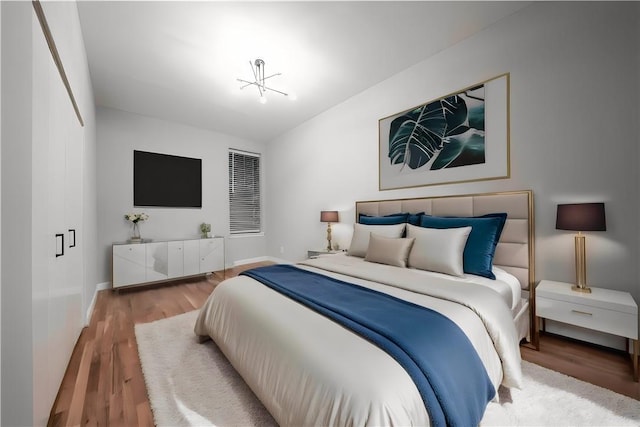 bedroom featuring a notable chandelier and wood-type flooring