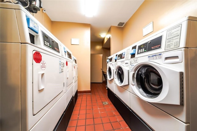 laundry area featuring stacked washer and dryer, washer and dryer, and dark tile patterned flooring