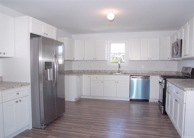 22 Rod St, East Patchogue, NY 11772 - kitchen with light stone counters, dark wood-style floors, white cabinets, appliances with stainless steel finishes, and a sink