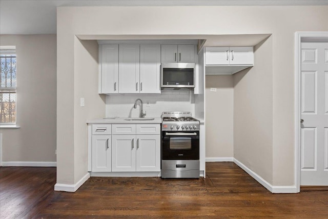 kitchen with tasteful backsplash, sink, white cabinets, and stainless steel appliances