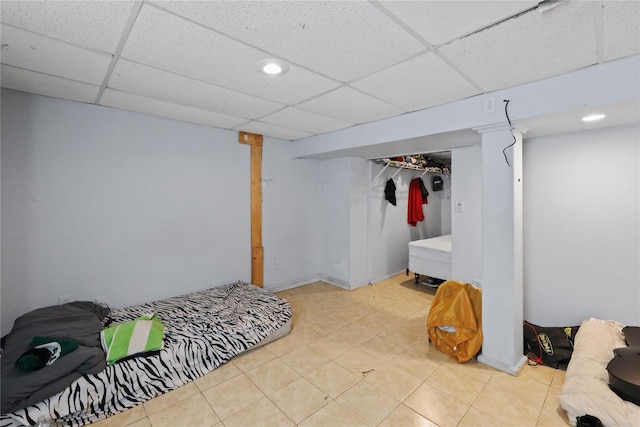 tiled bedroom with a closet and a drop ceiling