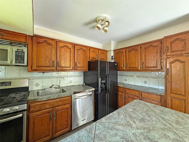 33 Birch Ct, Riverhead, NY 11901 - kitchen with stainless steel appliances, a sink, tasteful backsplash, brown cabinetry, and tile countertops