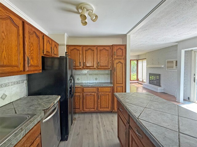 33 Birch Ct, Riverhead, NY 11901 - kitchen featuring dishwasher, brown cabinetry, light wood-style floors, tasteful backsplash, and brick wall
