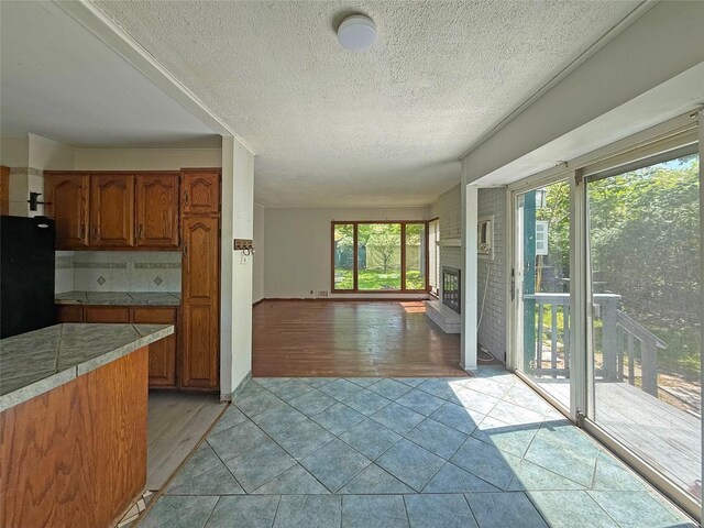 33 Birch Ct, Riverhead, NY 11901 - kitchen with brown cabinets, freestanding refrigerator, light wood-style flooring, a textured ceiling, and open floor plan