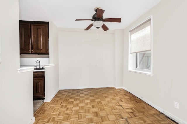 interior space featuring ceiling fan, sink, a wealth of natural light, and light parquet flooring