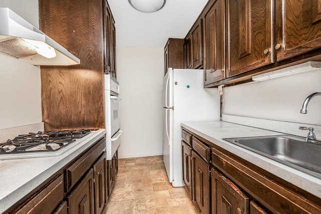 kitchen with sink, white appliances, dark brown cabinetry, and range hood