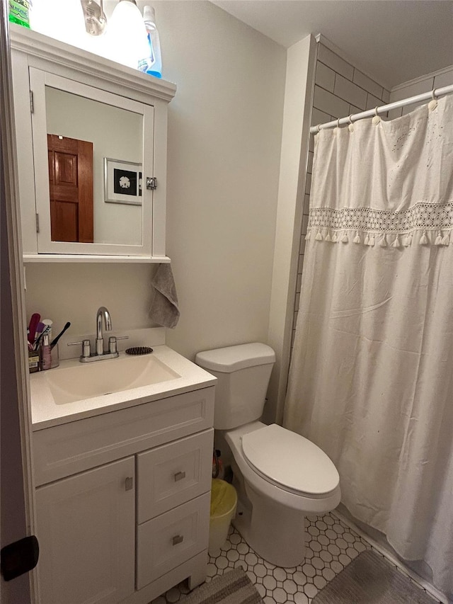 bathroom with tile patterned floors, a shower with curtain, vanity, and toilet