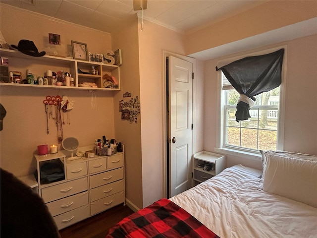 bedroom with dark hardwood / wood-style floors and ornamental molding