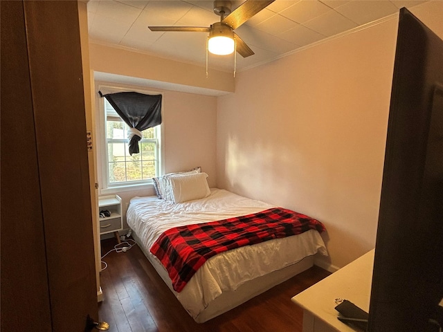 bedroom with ceiling fan, dark hardwood / wood-style floors, and crown molding