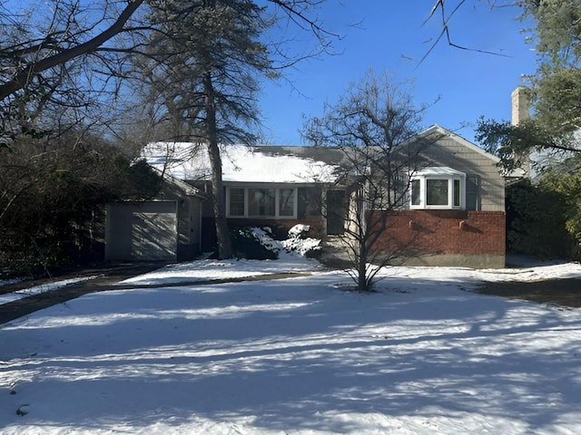 view of front of home featuring brick siding, driveway, and a garage