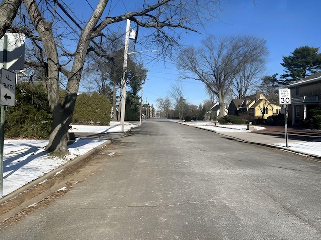 view of road featuring curbs, traffic signs, and sidewalks