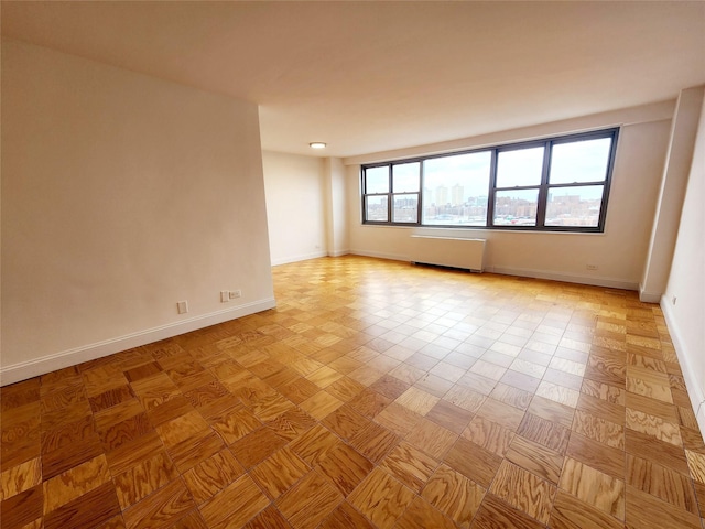 empty room featuring radiator heating unit and light parquet flooring