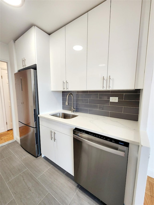 kitchen featuring appliances with stainless steel finishes, white cabinetry, and sink