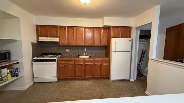 kitchen featuring white appliances, backsplash, and sink