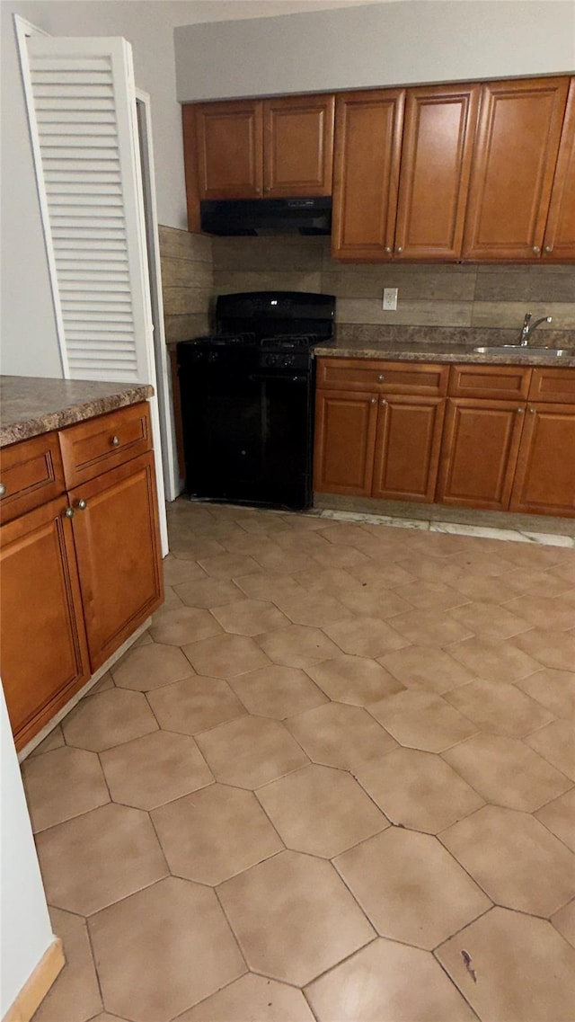 kitchen featuring black gas range oven and sink