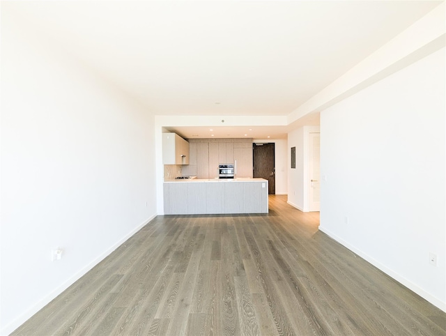 unfurnished living room featuring baseboards and light wood-style floors