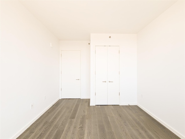 unfurnished room with baseboards and wood finished floors