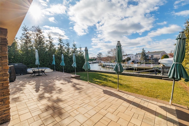 view of patio / terrace with a boat dock, a water view, and grilling area