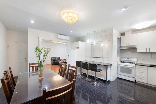 dining room featuring a wall unit AC and a notable chandelier