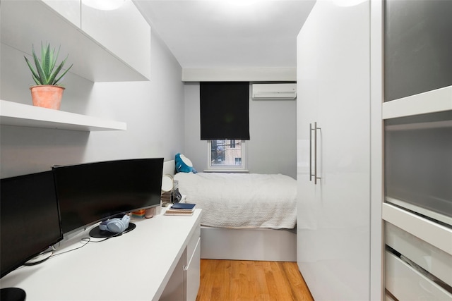 bedroom featuring a wall mounted air conditioner and light wood-type flooring