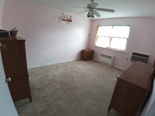 carpeted empty room featuring an AC wall unit, radiator, and ceiling fan