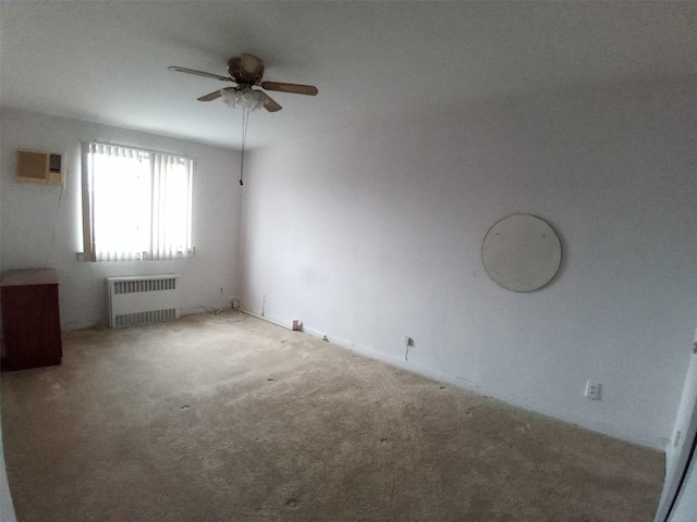 carpeted empty room featuring radiator heating unit, an AC wall unit, and ceiling fan