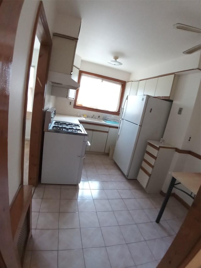 kitchen featuring white cabinets, light tile patterned floors, white appliances, and sink