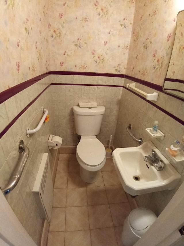 bathroom with tile patterned flooring, sink, toilet, and tile walls