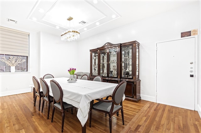 dining area with an inviting chandelier and light hardwood / wood-style flooring