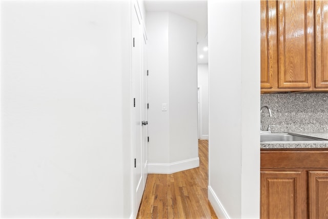 hall with light hardwood / wood-style floors and sink