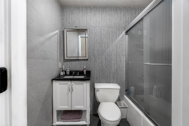 full bathroom with vanity, toilet, and bath / shower combo with glass door