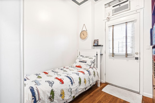 bedroom featuring a wall mounted air conditioner and dark hardwood / wood-style flooring