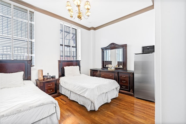 bedroom featuring a notable chandelier, light wood-type flooring, crown molding, and multiple windows