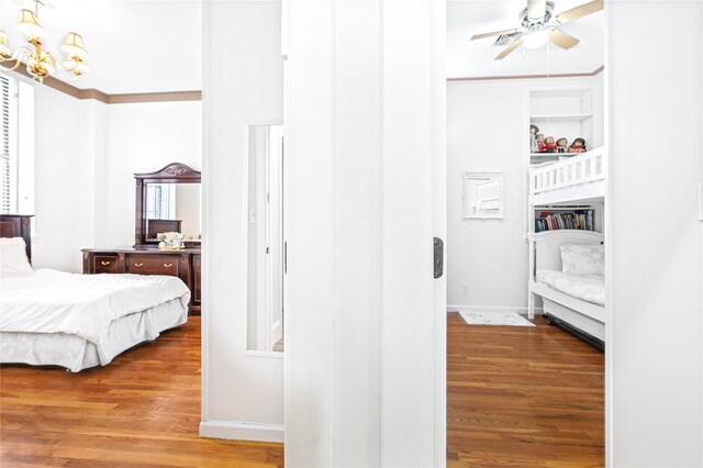 bedroom with hardwood / wood-style floors and ceiling fan with notable chandelier