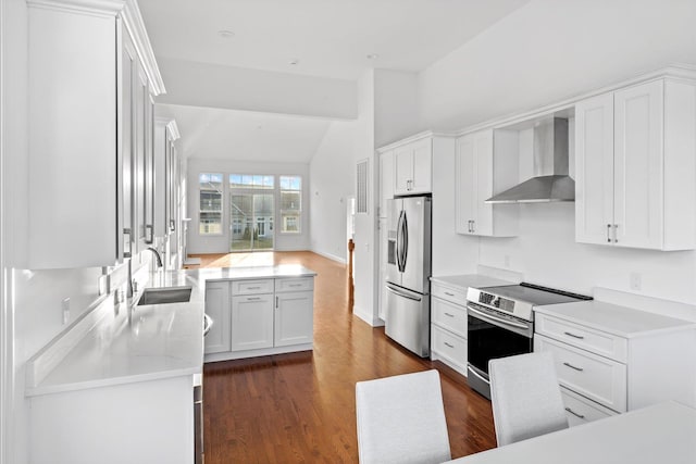 kitchen featuring white cabinetry, sink, dark wood-type flooring, wall chimney range hood, and appliances with stainless steel finishes