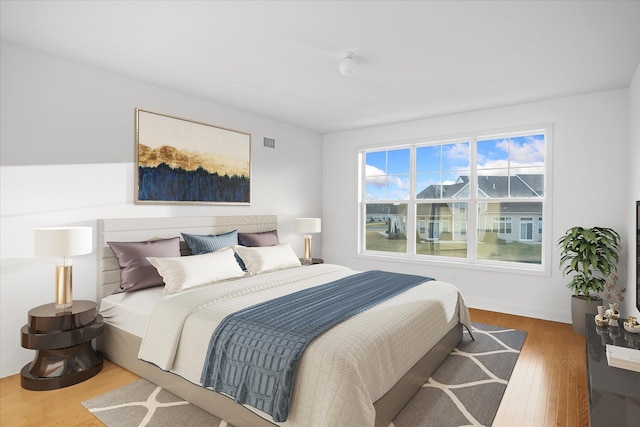 bedroom with hardwood / wood-style floors and multiple windows