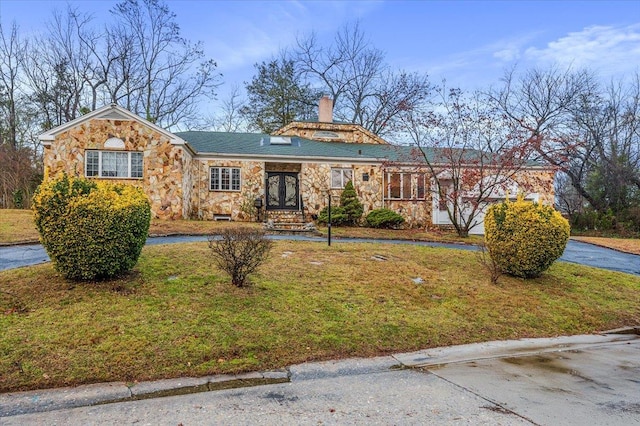 ranch-style house with a front yard and french doors