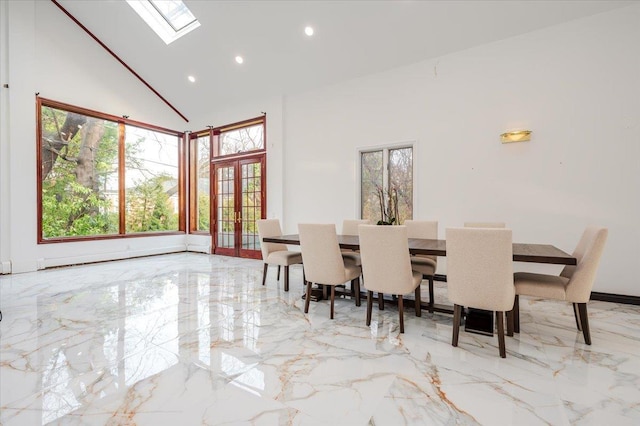 dining space with a high ceiling, a skylight, french doors, and a baseboard heating unit