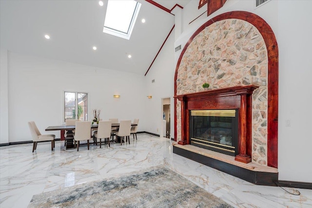 dining room with a skylight and high vaulted ceiling